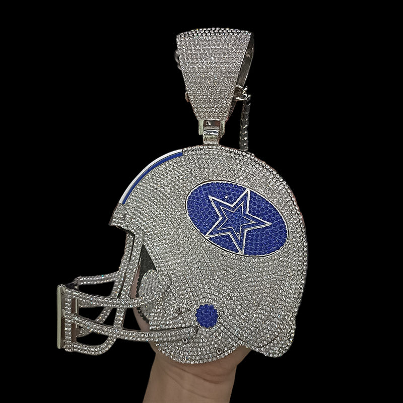 Silver helmet-shaped pendant with blue star emblem held by a hand against a dark background