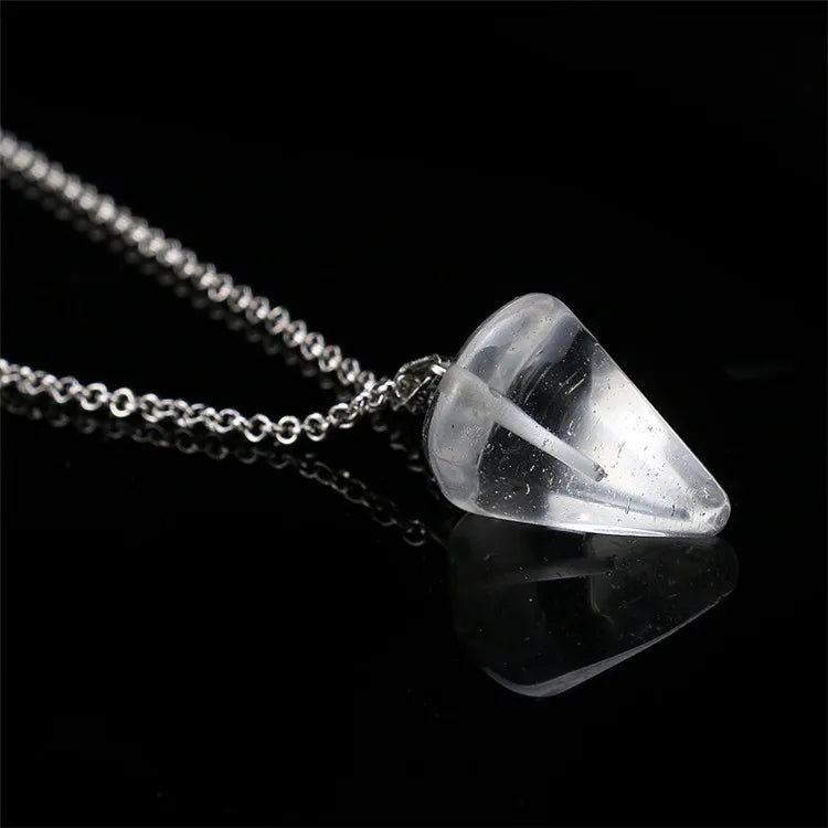 Clear crystal pendant on a silver chain against a black background