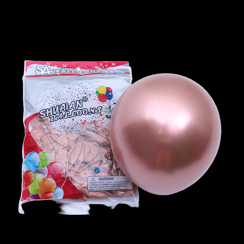 Shiny rose gold balloon next to a package of balloons on a white background