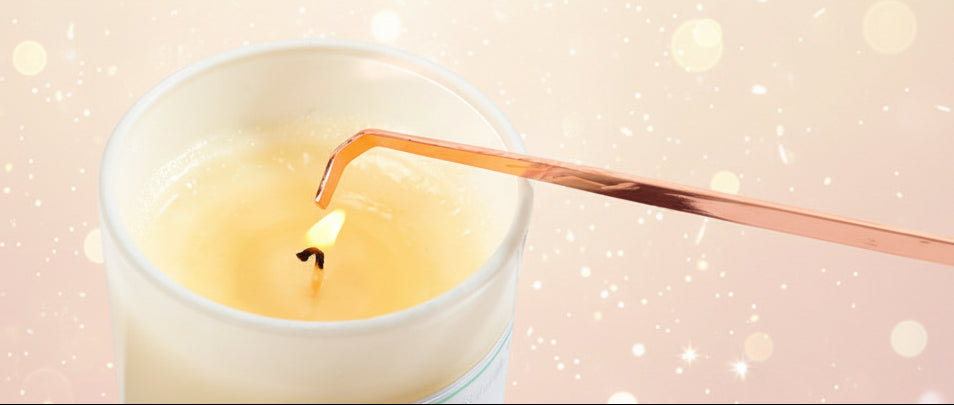 Candle being lit with a wooden wick in a white container.