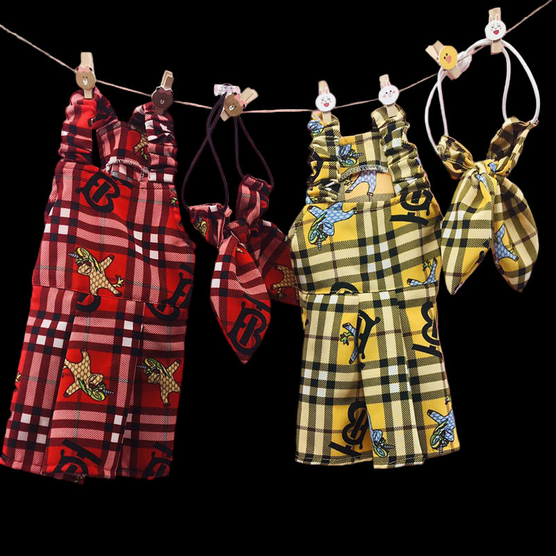 Plaid outfits with graphic designs hanging on a line against a pink background