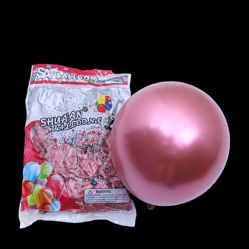 Pink balloon next to its packaging on a white background
