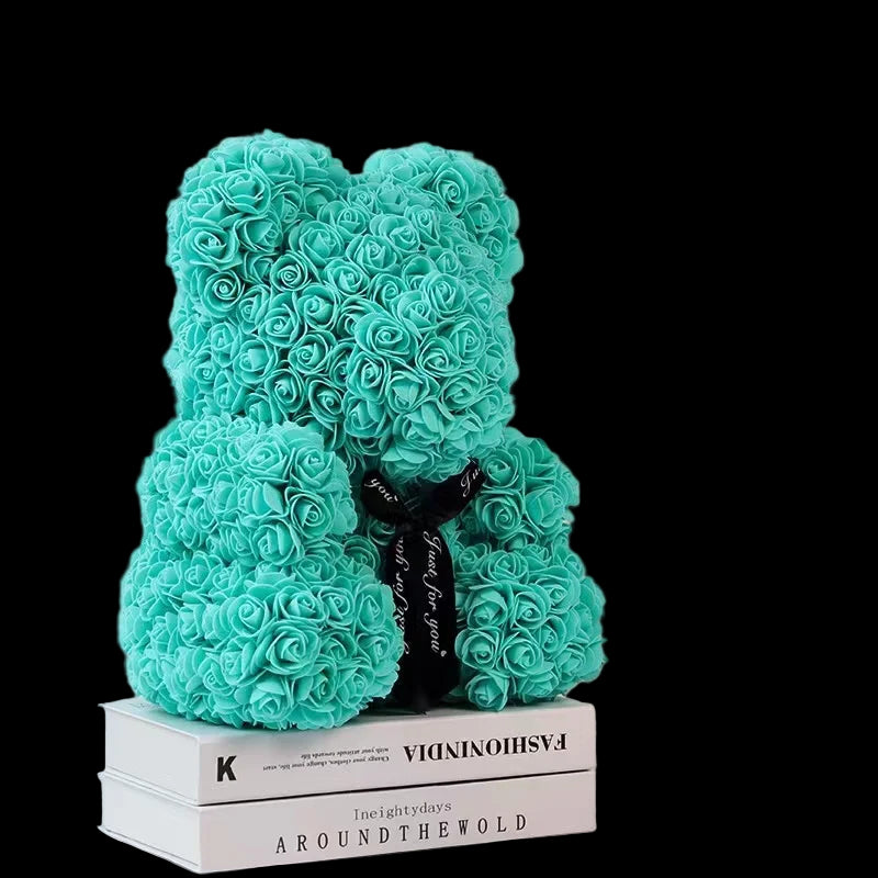Turquoise rose bear on books with a white background