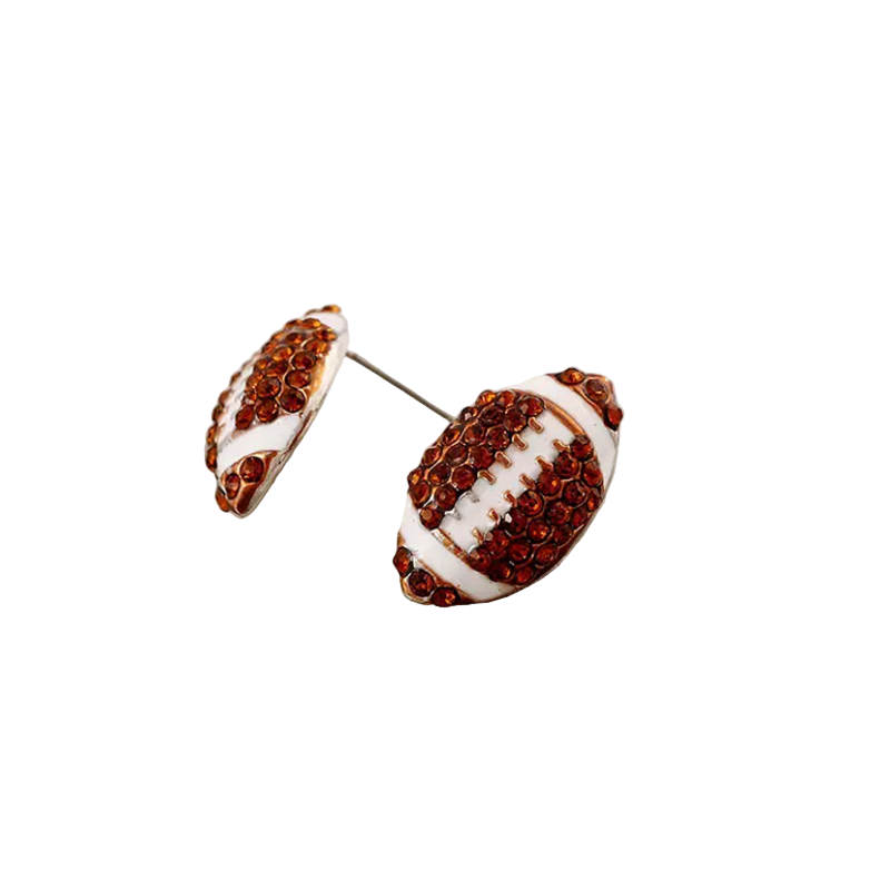 Football-shaped earrings with brown and white design on a textured surface.