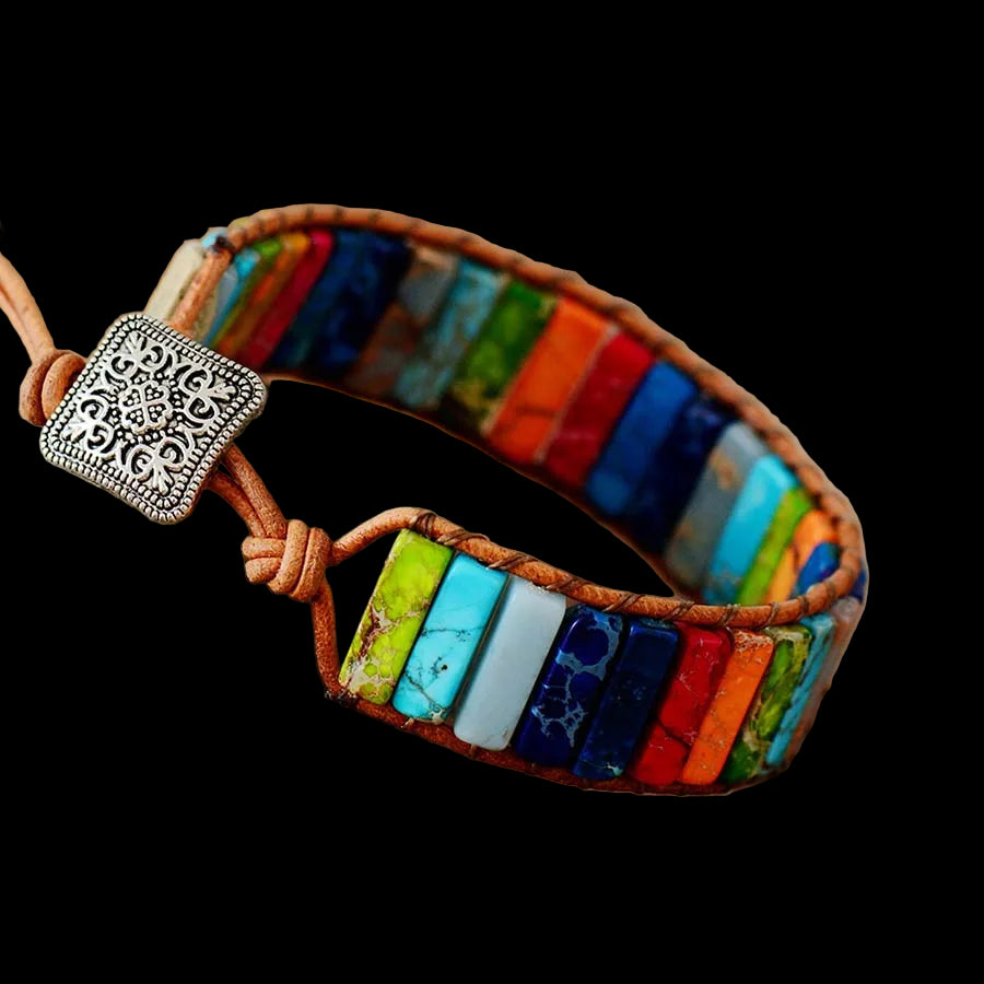 Colorful beaded bracelet with a patterned clasp on a wooden surface