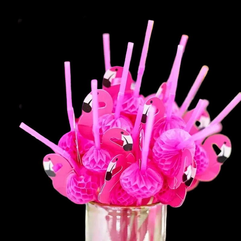 Pink flamingo-themed straws in a clear container with a blurred floral background