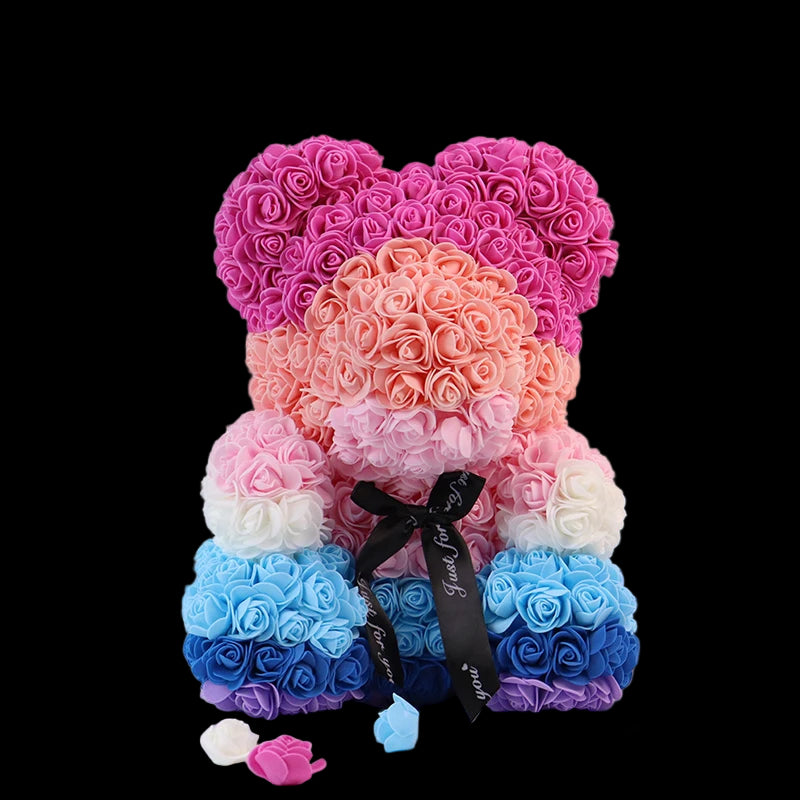 Colorful flower teddy bear with a gradient from pink to blue on a white background.