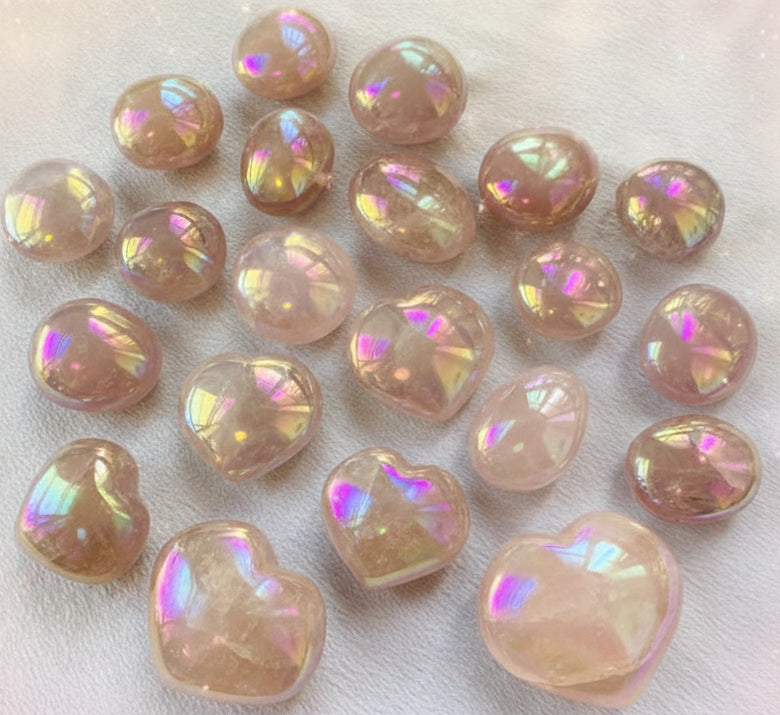 Heart-shaped iridescent beads on a white fabric background