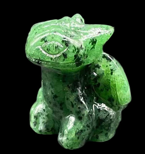Green crystal frog figurine on a dark gray surface