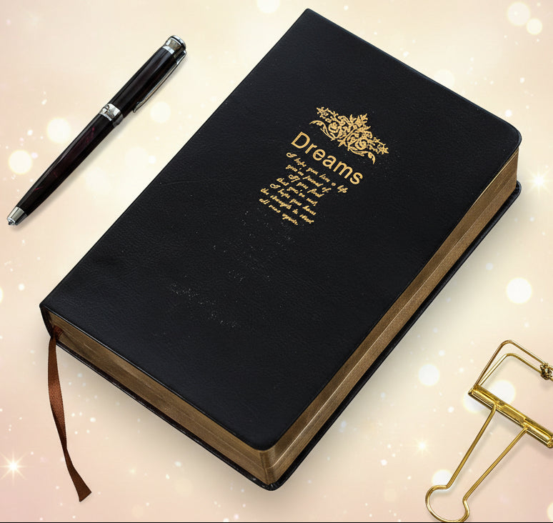 Black notebook with 'Dreams' on a textured surface