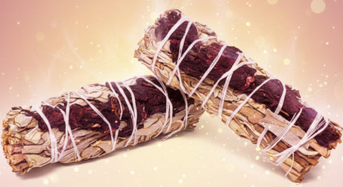 Two smudge sticks tied with white string on a white background