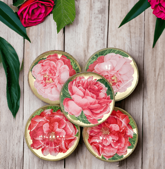 Set of floral coasters with pink flowers on a wooden surface