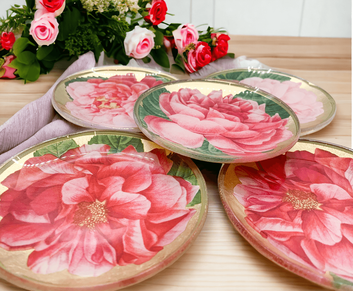 Set of floral coasters with pink flowers on a wooden surface