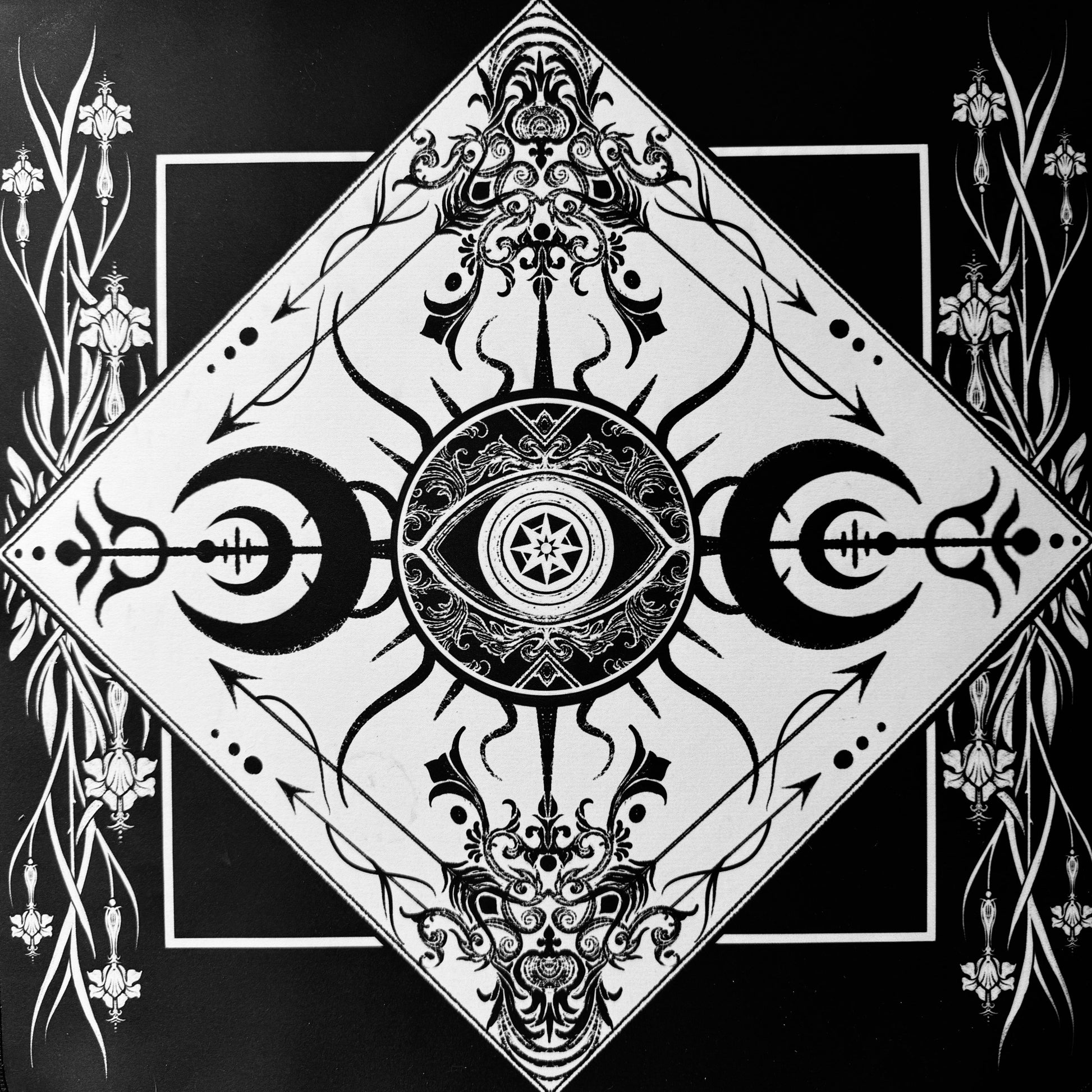 Black and white gothic-style graphic art print featuring a central eye motif surrounded by ornate floral and crescent moon designs, arranged within a diamond-shaped border on a black background.