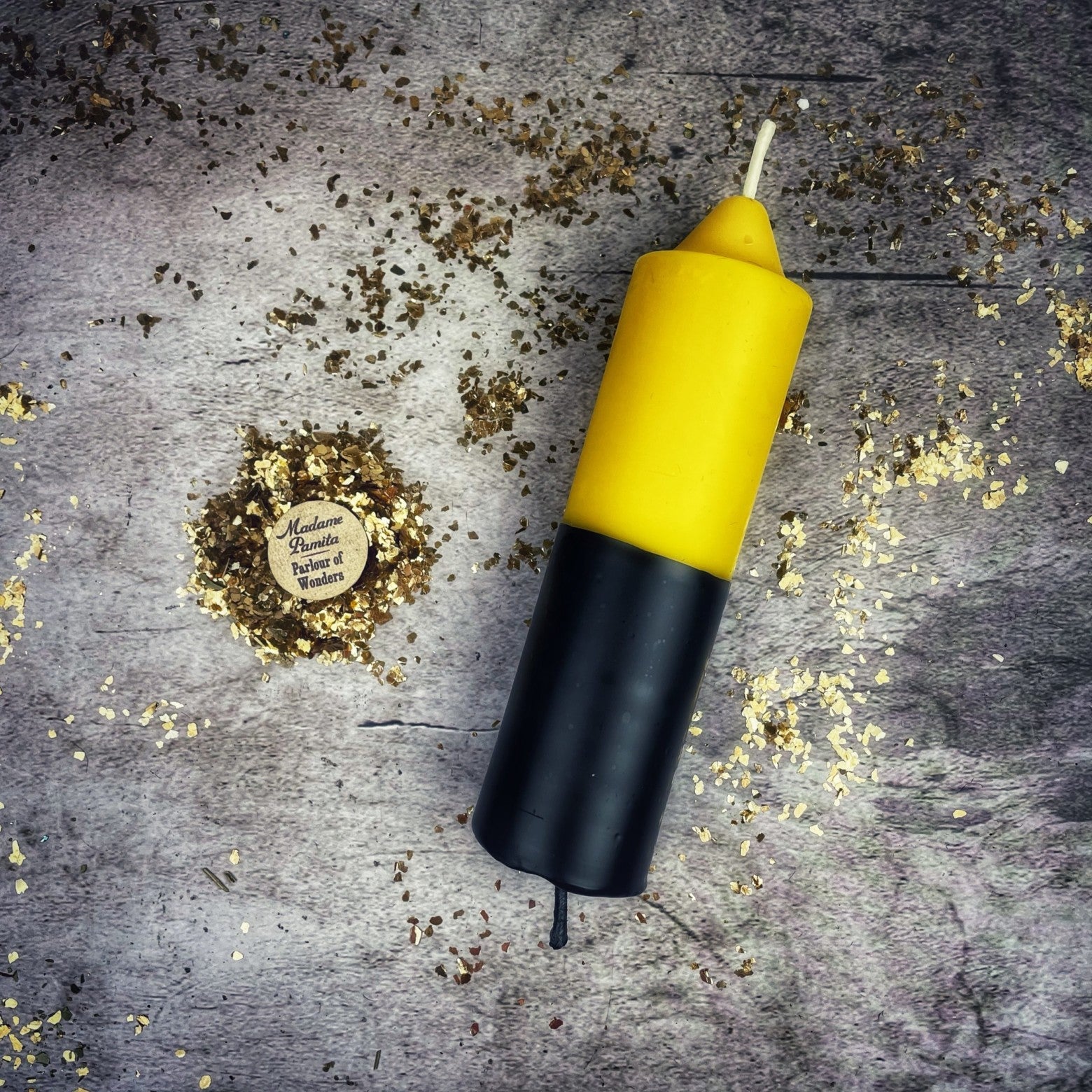 Yellow and black device on a textured surface with gold confetti