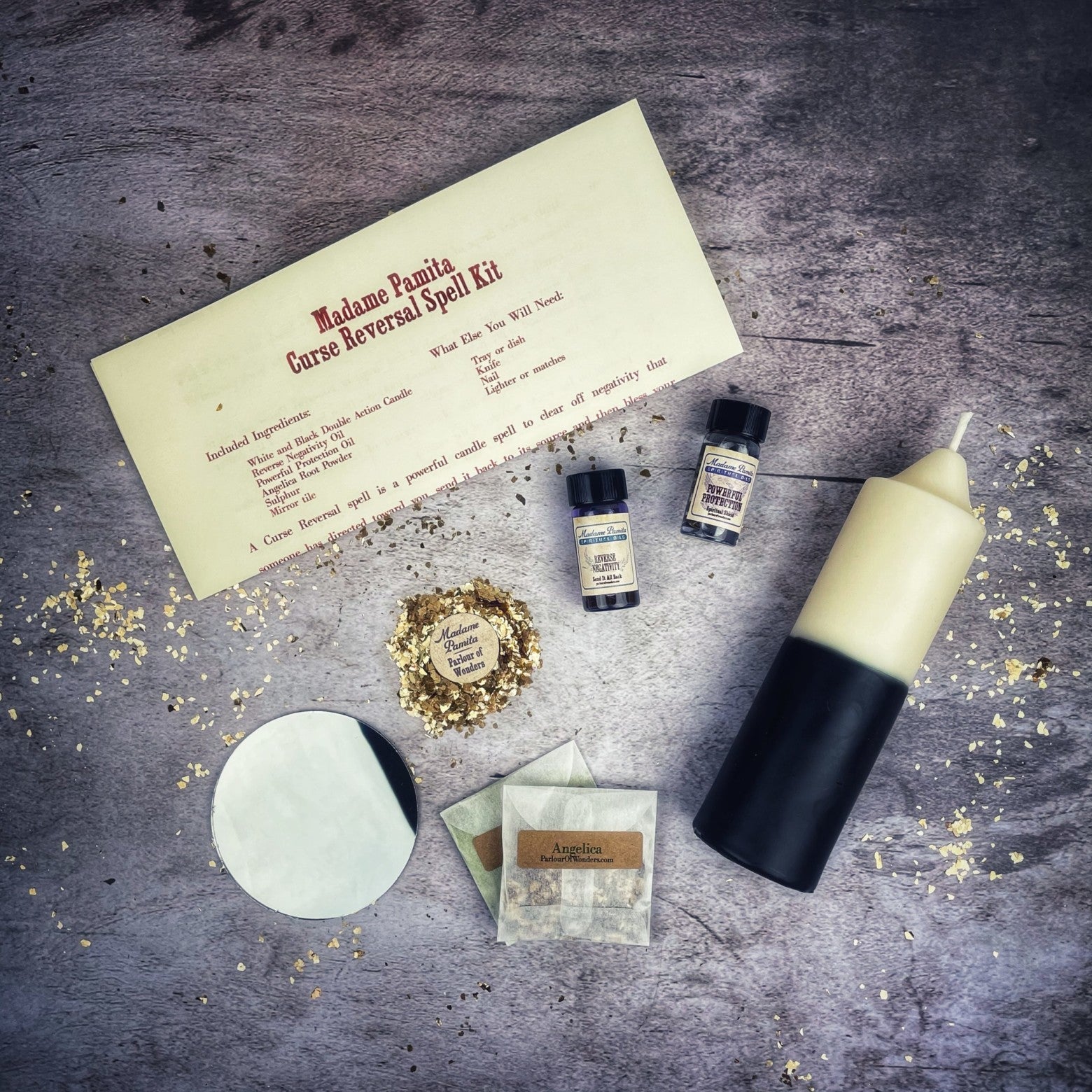 Spell kit with a candle, bottles, and a piece of paper on a textured surface