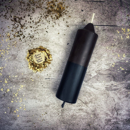 Black cylindrical object on a textured surface with gold confetti
