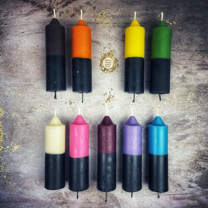 Colorful candles with black下半部分 on a textured surface