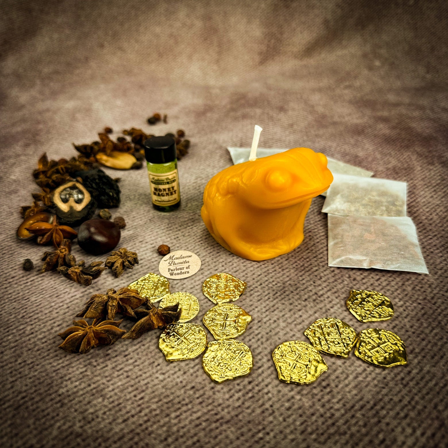 Spices, gold coins, a bottle, and other items on a textured surface