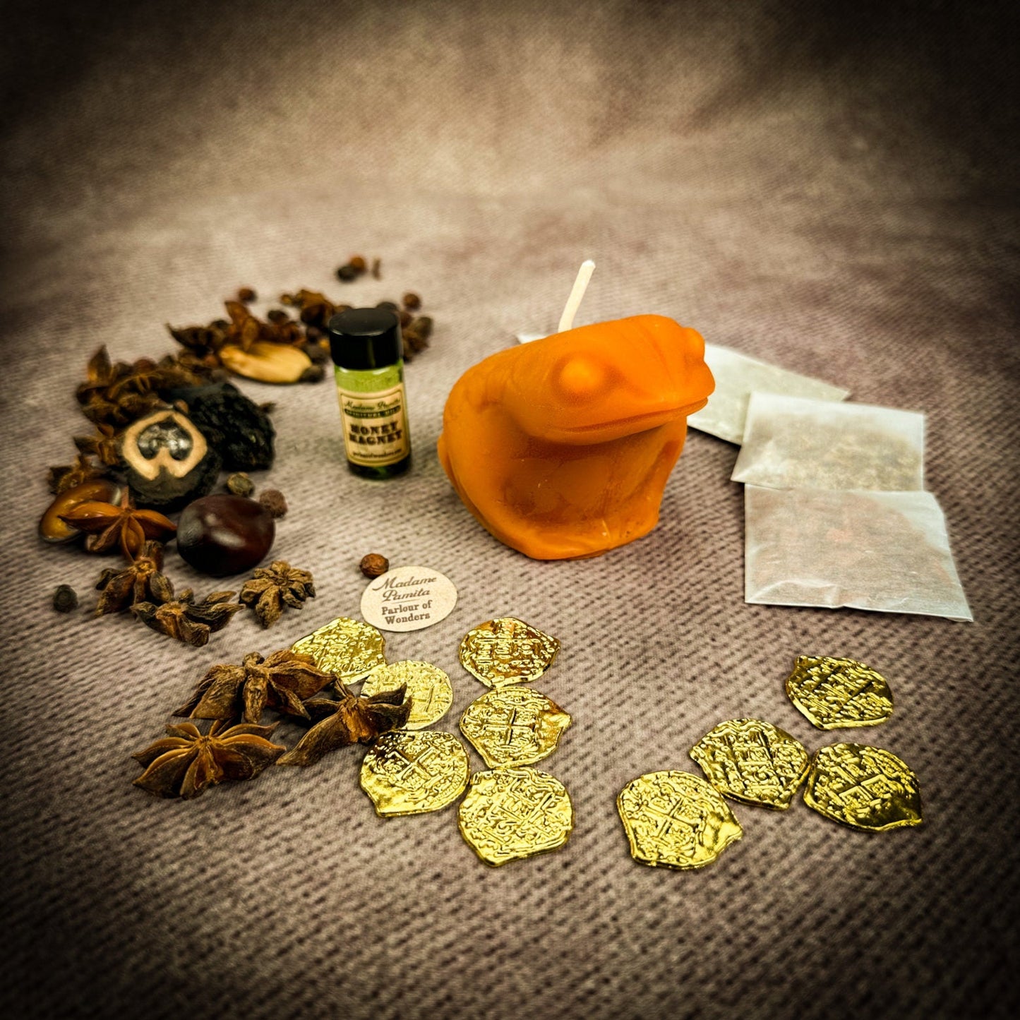 Spices, gold coins, and a bottle on a textured surface