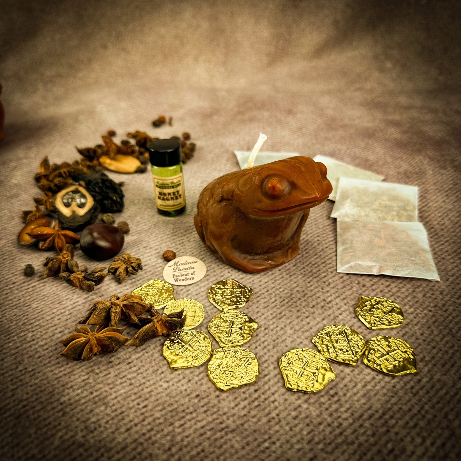 Spices, gold coins, a wooden frog, and a bottle on a textured surface