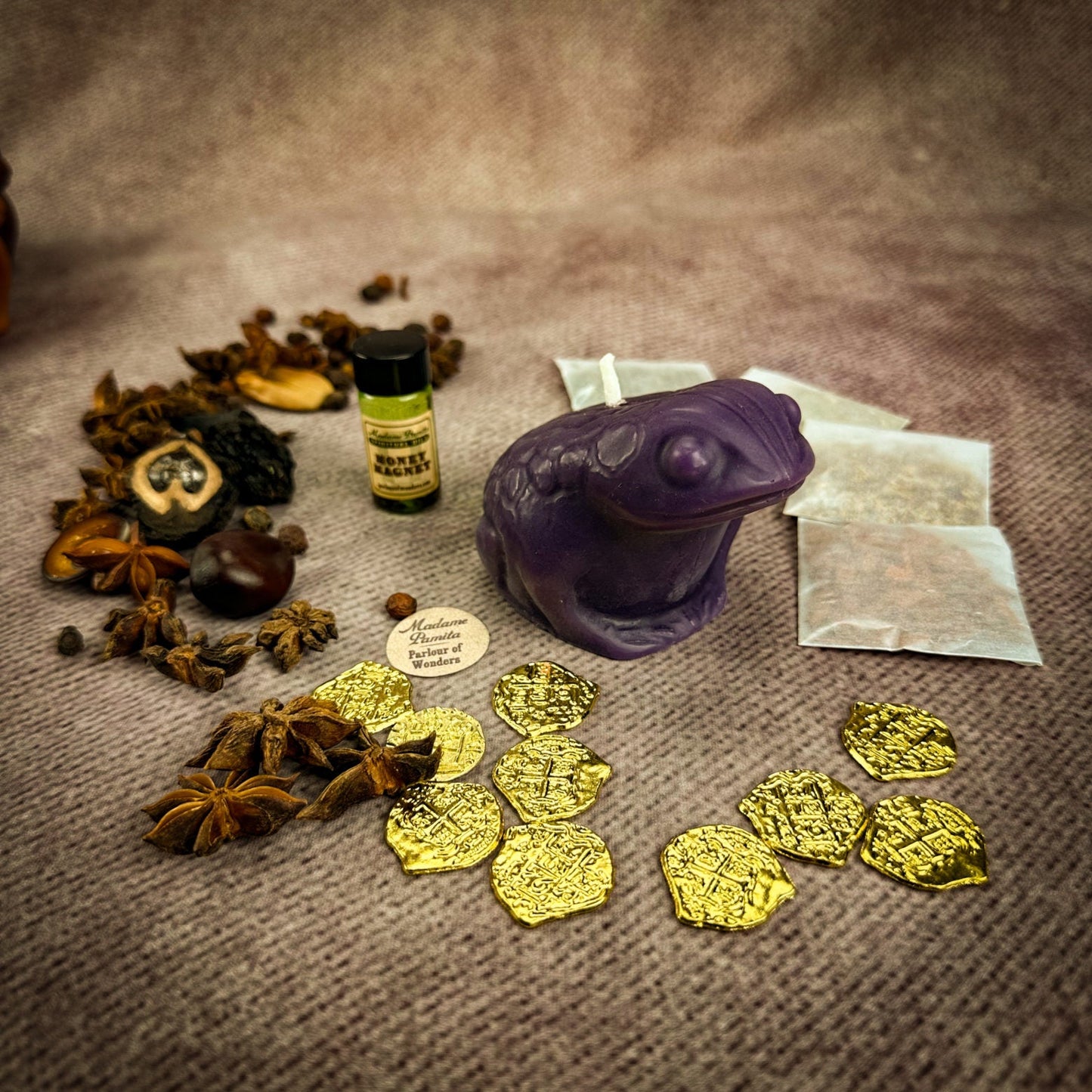 Spices, a bottle, and gold coins on a textured surface