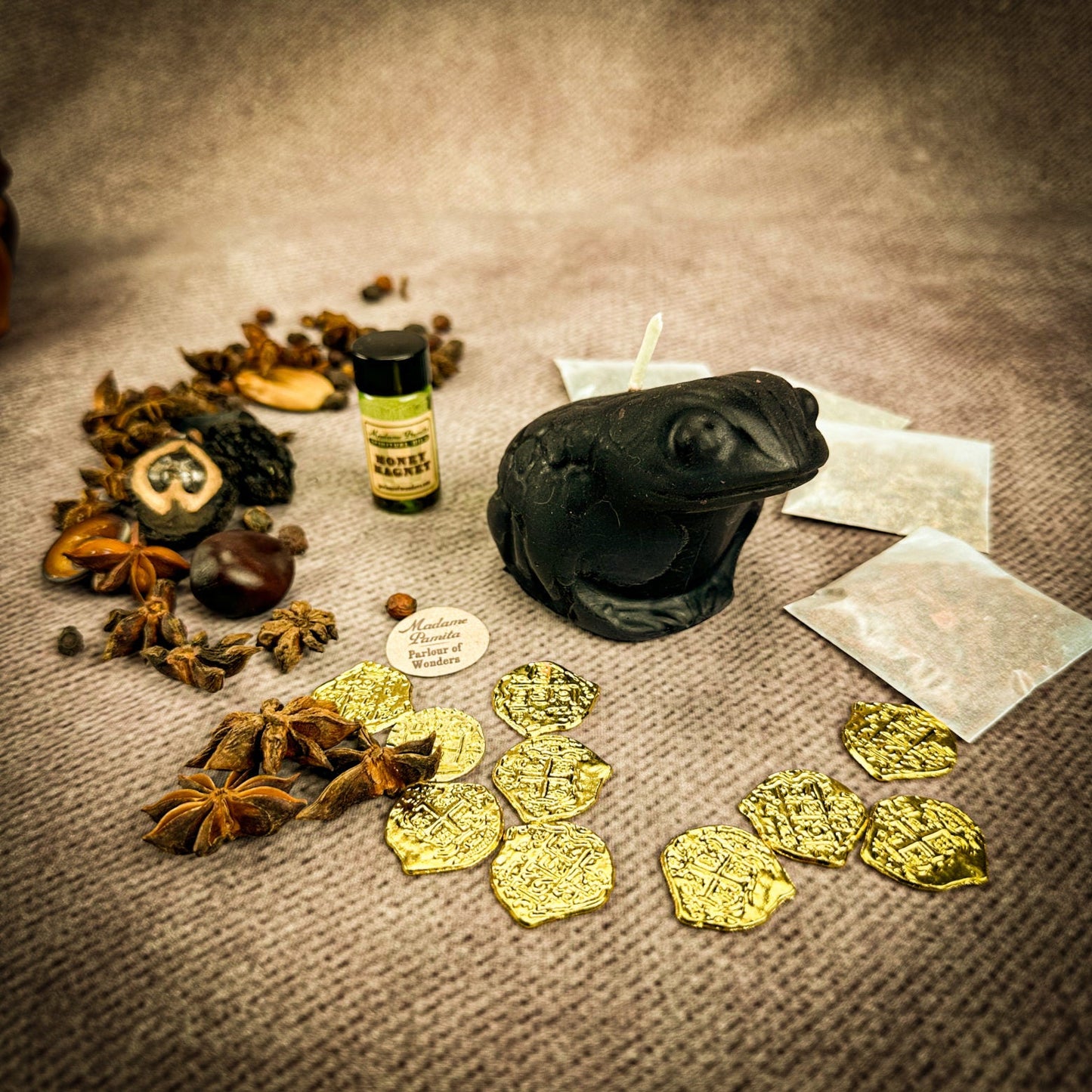 Spices, a bottle, and gold coins on a textured surface