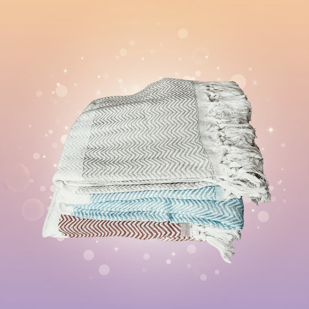 Stack of patterned towels on a marble surface with decorative elements in the background