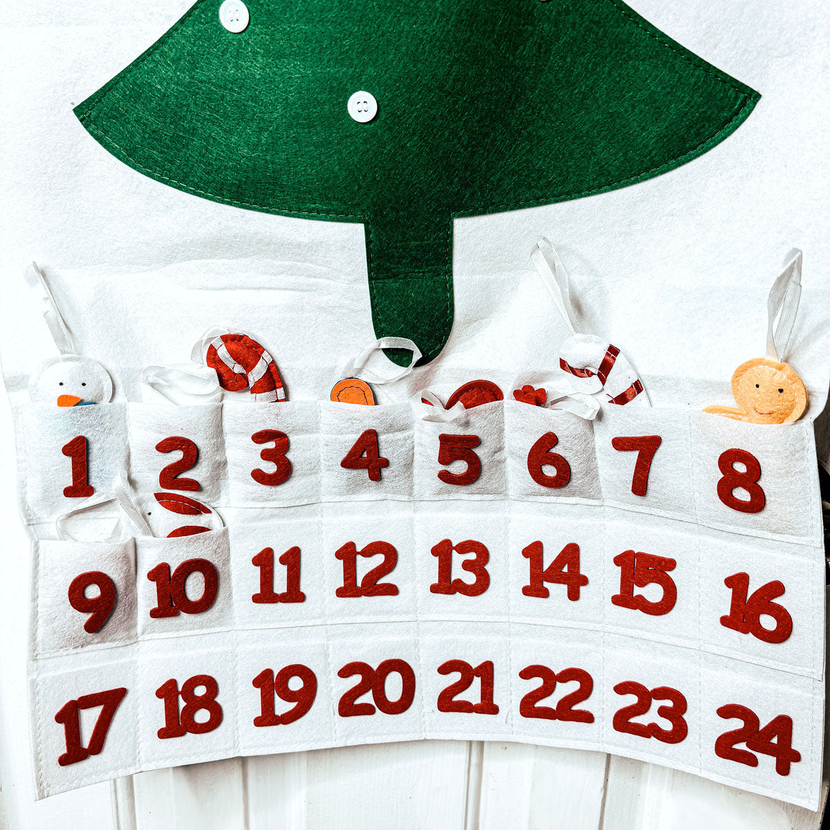 Advent calendar with numbered sections and Christmas tree design on a white background