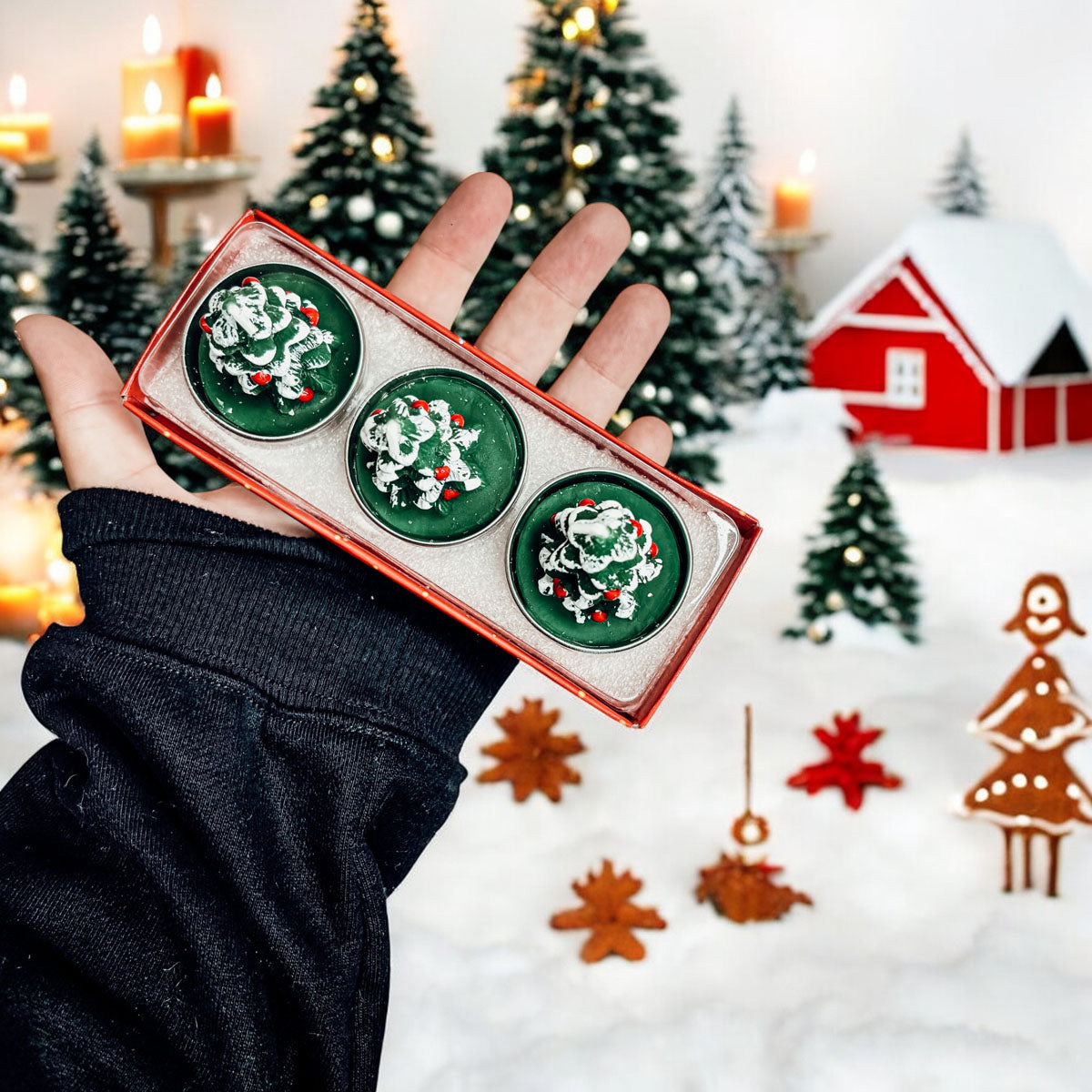 Hand holding a set of green Christmas-themed cookies with festive background