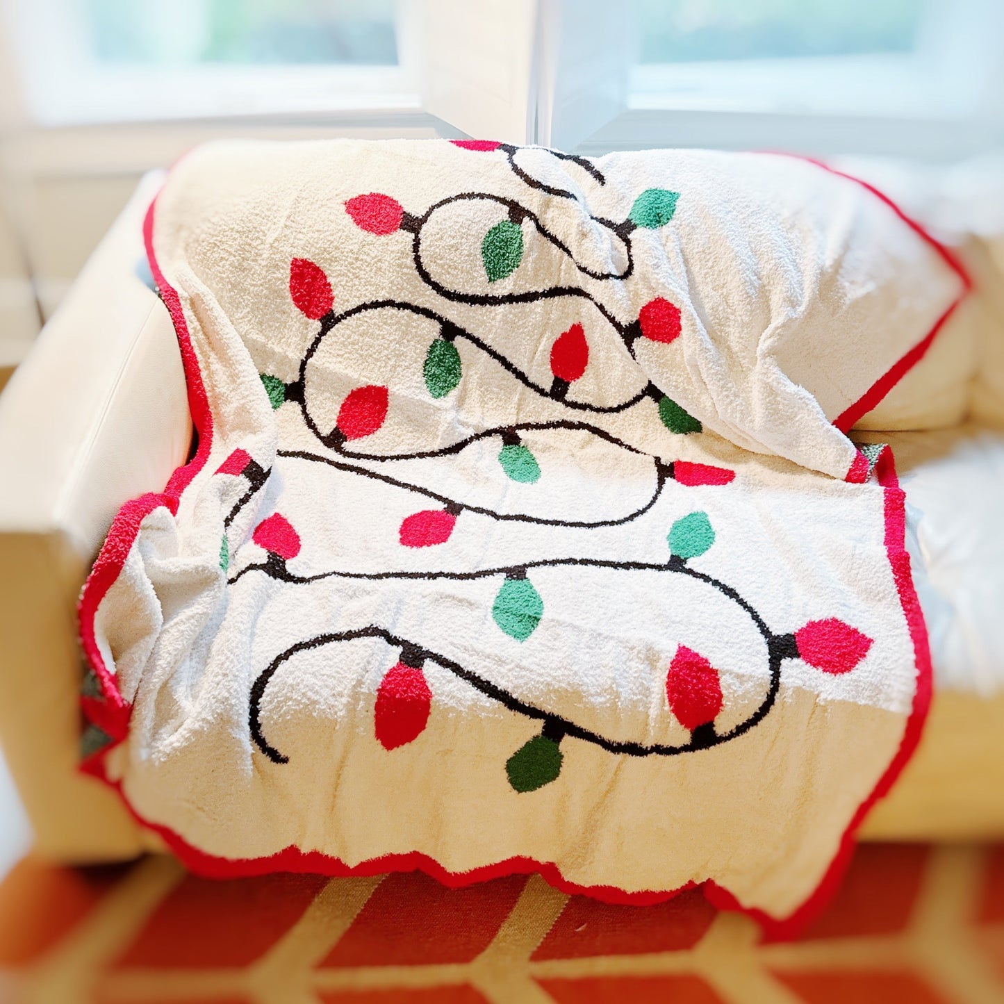 Decorative towel with Christmas lights design on a couch.