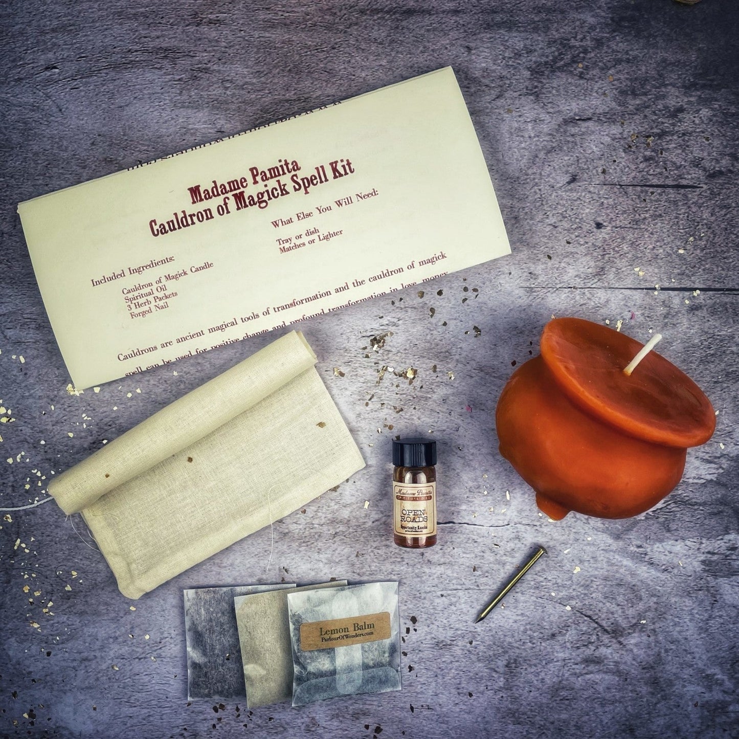 Magical spell kit with candle, paper, and small bottle on a textured surface