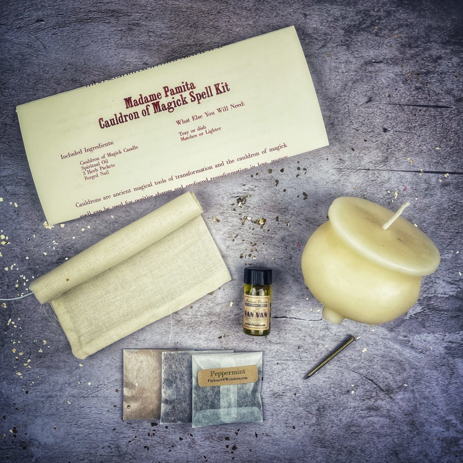 Magickal spell kit with candle, herbs, and paper on a textured surface