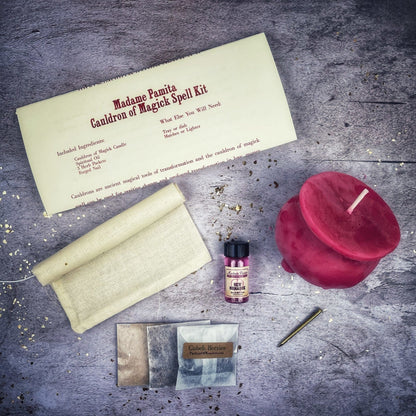 Magical spell kit with a red candle, scroll, and other items on a textured surface