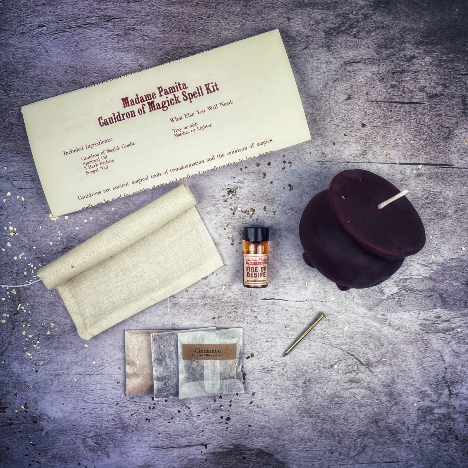 Magical spell kit with a candle, scroll, and other items on a textured surface