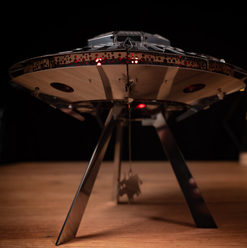 Model of a UFO on a wooden surface with a dark background