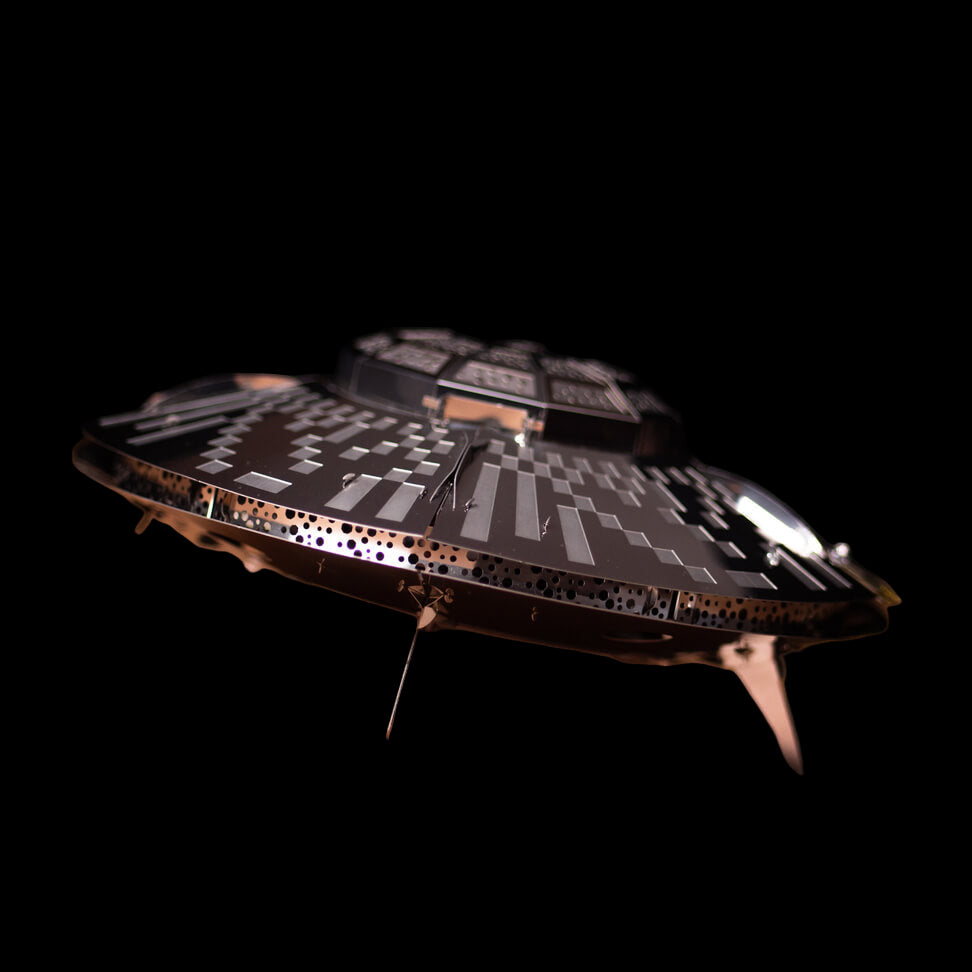 Model of a spaceship on a wooden surface with a dark background