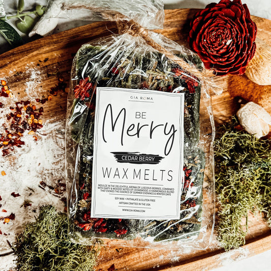 Packaged wax melts labeled 'Be Merry' with decorative elements on a wooden surface.