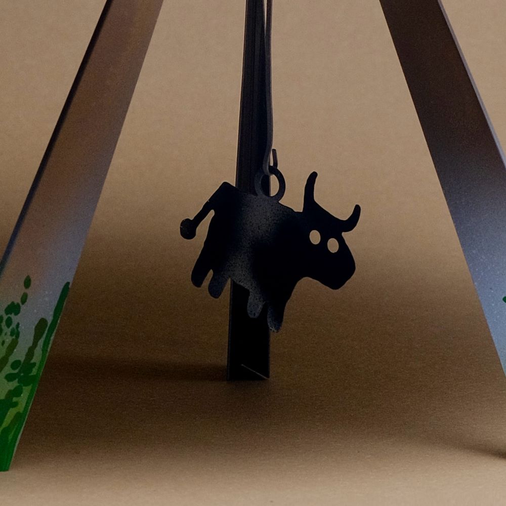 Black cow-shaped clip on a brown background