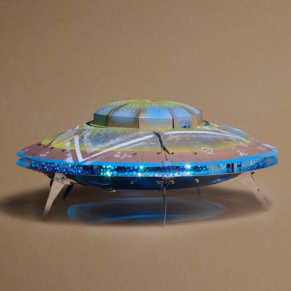 Model of a UFO with glowing blue lights on a beige background