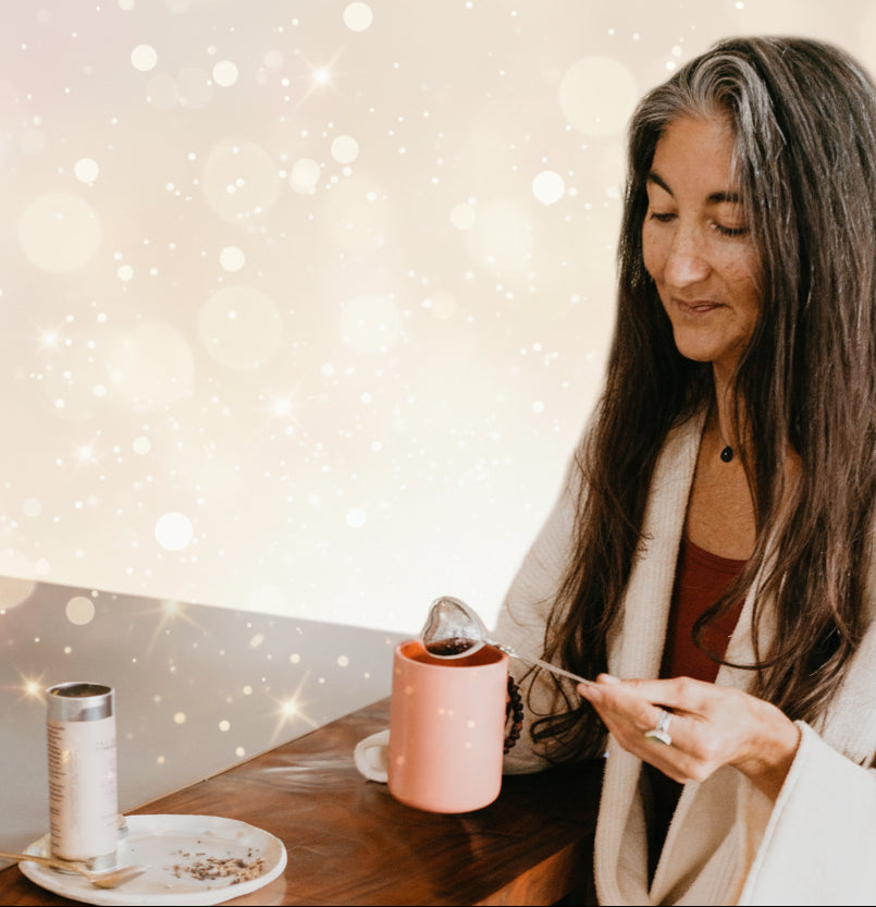 Woman sitting at a kitchen counter eating cereal with a spoon.