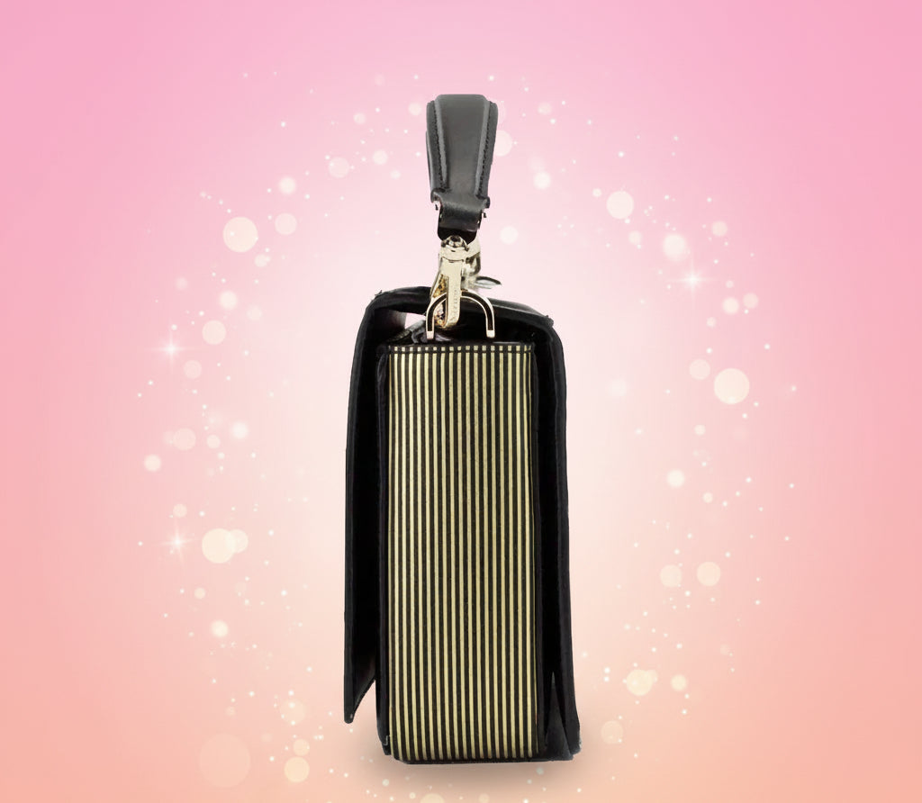 Black and gold handbag with a strap on a white background