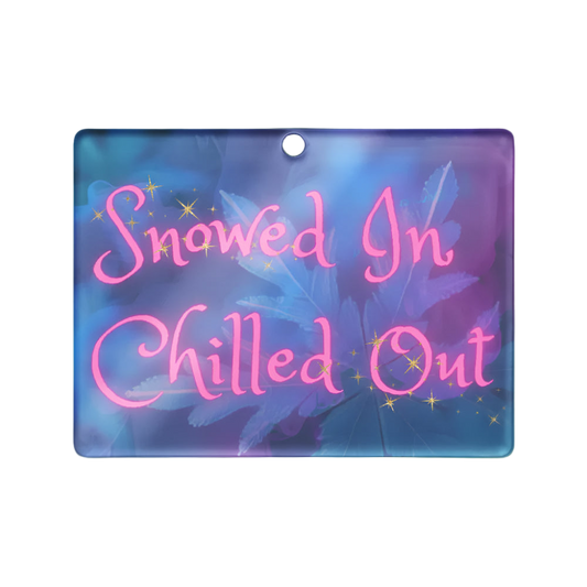 Decorative sign with 'Snowed In Chilled Out' text on a blue and pink gradient background