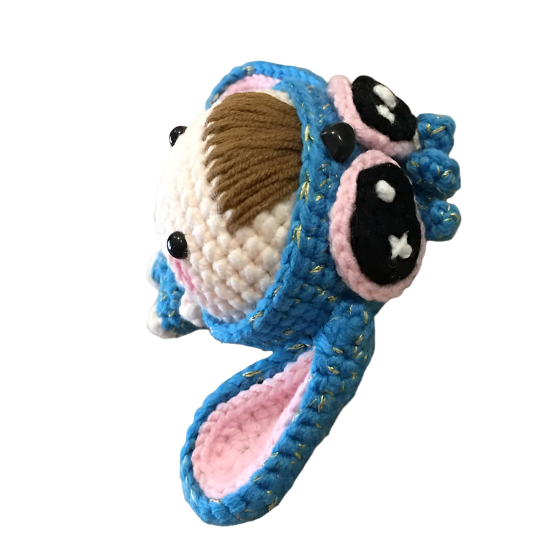 Crocheted shark plush toy on a textured beige surface