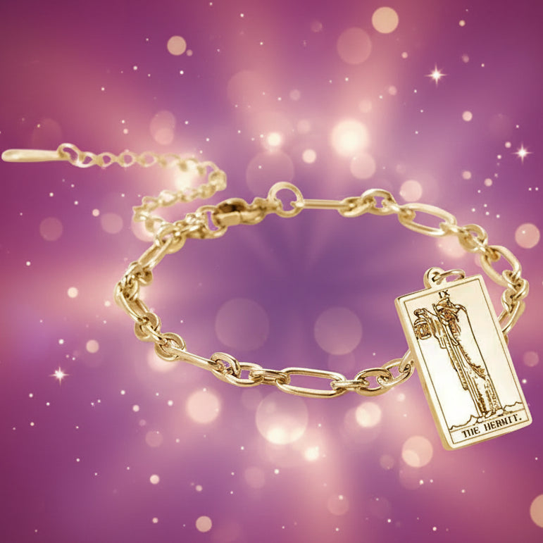 Gold bracelet with a tarot card charm on a white background