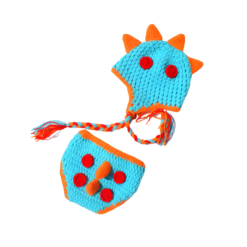 Crocheted dinosaur hat and diaper set on a white background