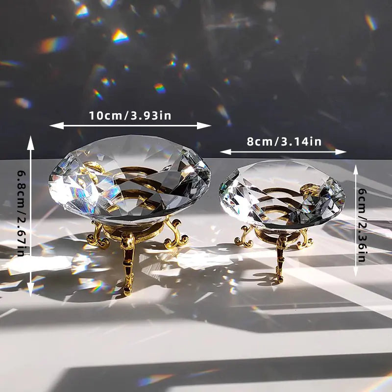 Two crystal stands with gold bases on a reflective surface, showing measurements.