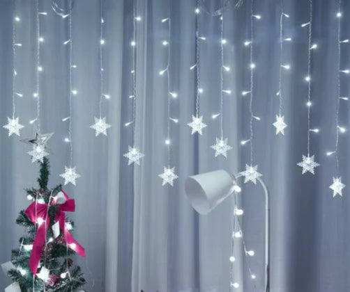 Decorative string lights shaped like stars with a Christmas tree and gift box against a curtain background.