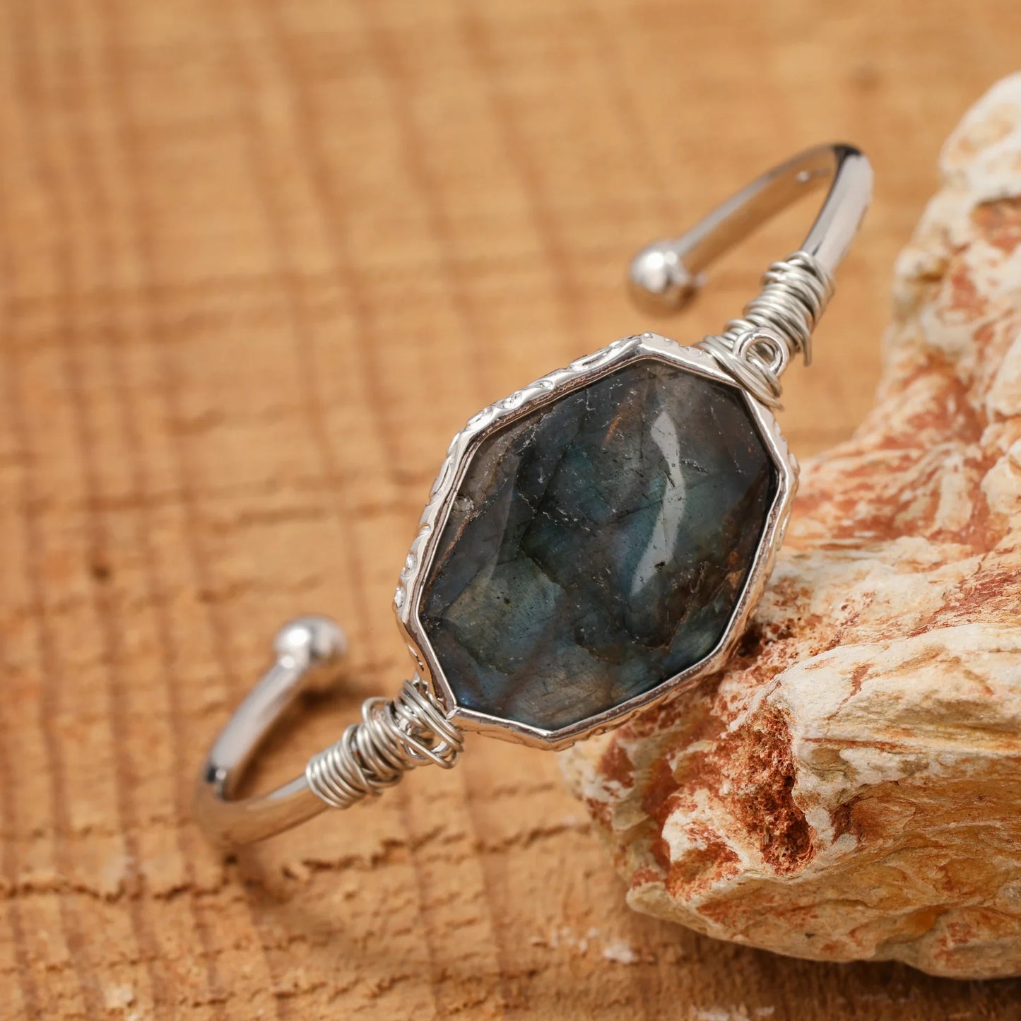 Silver bracelet with a large stone on a wooden surface