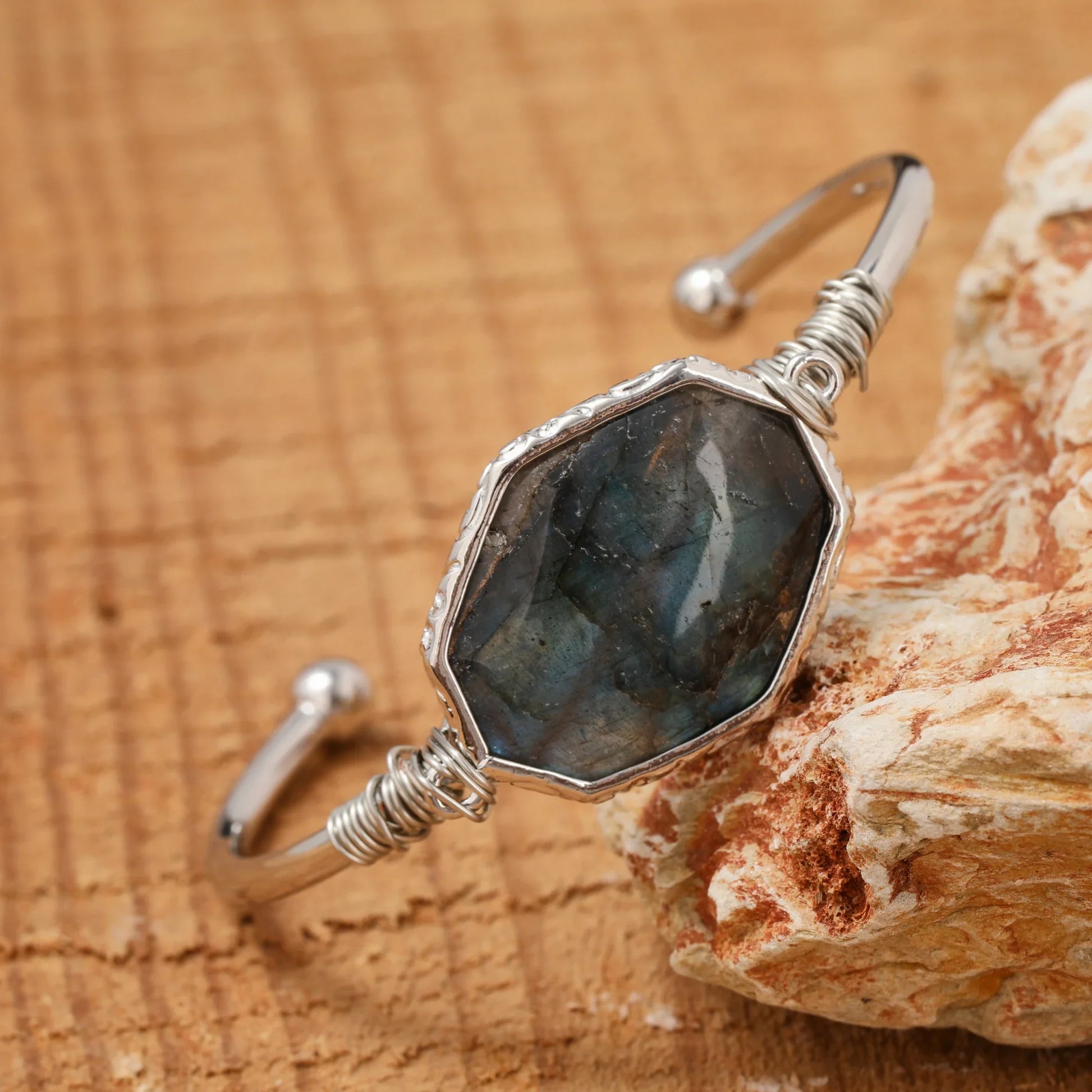 Silver bracelet with a large stone on a wooden surface